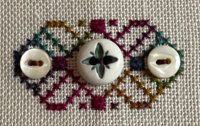 Stitched motif with white antique buttons